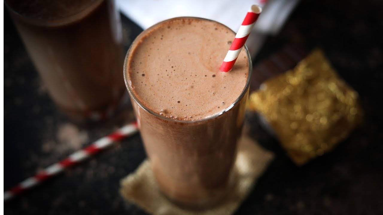 A thick chocolate keto breakfast shake in a glass topped with a light dusting of cocoa powder