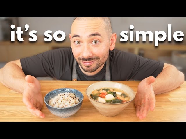 A Japanese-style breakfast rice bowl topped with flaked salmon, cubed tofu, wilted spinach, cherry tomatoes, and sesame seeds, served with a small bowl of miso soup