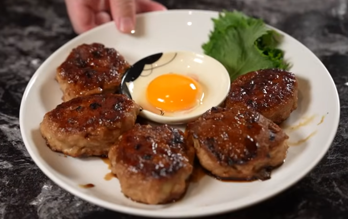 Japanese meatballs browning in a skillet before steaming