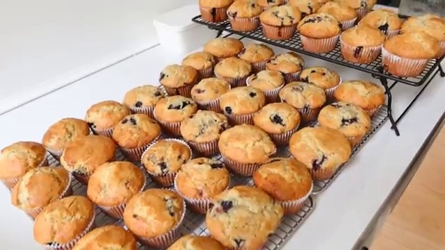 Freezer breakfast burritos, smoothie packs, and blueberry muffins laid out and ready for freezing