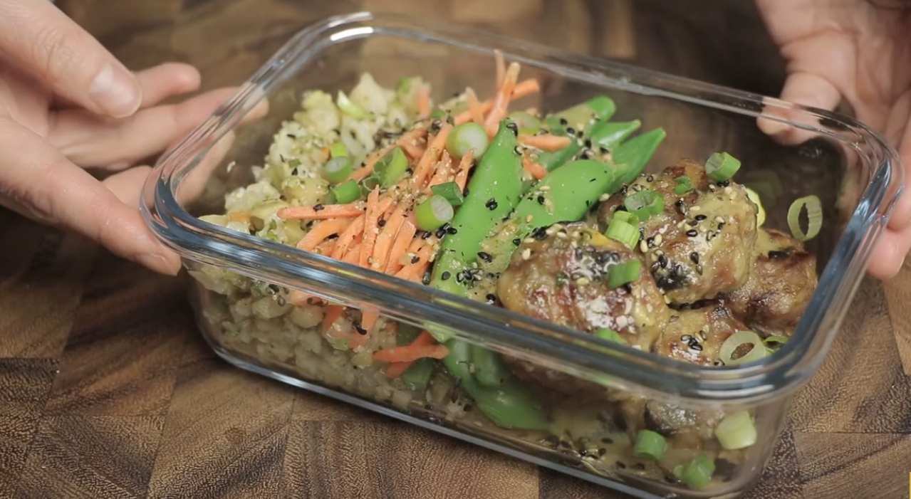 Paleo meal prep gyoza meatballs in containers with cauliflower rice, snow peas and shredded carrots