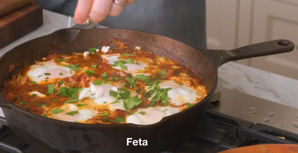 Eggs set into wells in the thick tomato sauce