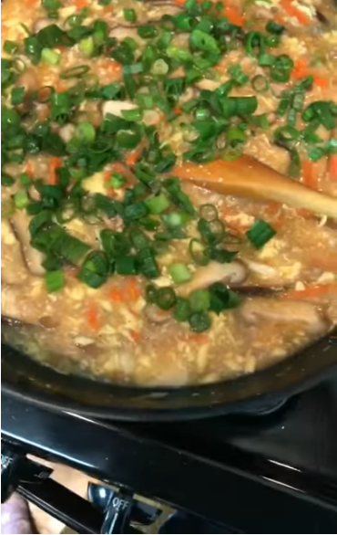 Bowl of paleo hot and sour soup gluten free with egg ribbons, shiitake mushrooms, pork and sliced scallions