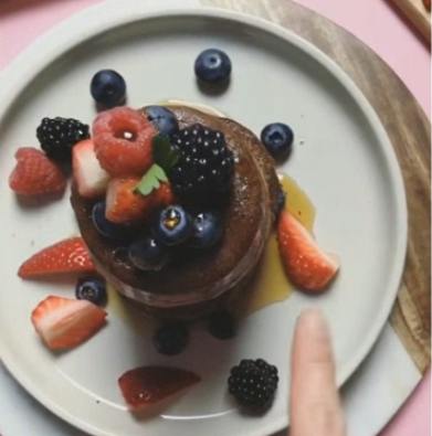 Stack of thick tigernut flour chocolate souffle pancakes served with maple syrup